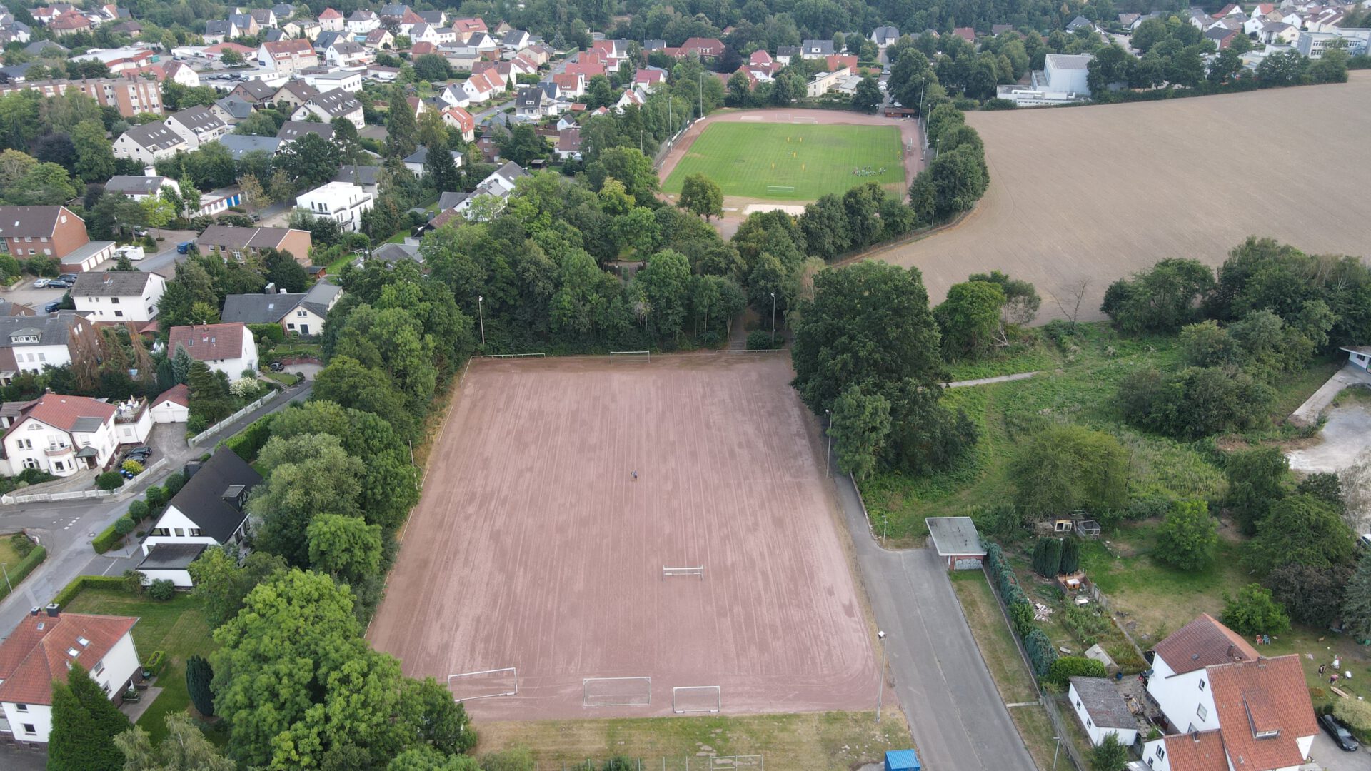 Luftaufnahme von der gesamten Sportanlage in Löhne-Gohfeld mit Blick nach Süden. Im Süden das Stadion am Mittelbach mit Naturrasen, im Norden der Sportplatz an der Nordbahnstraße mit bisher Asche.